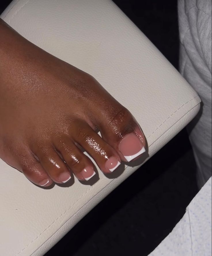 Elegant French Tip Pedicure: Soft Pink Base with Glossy White Tips for a Sophisticated Look.