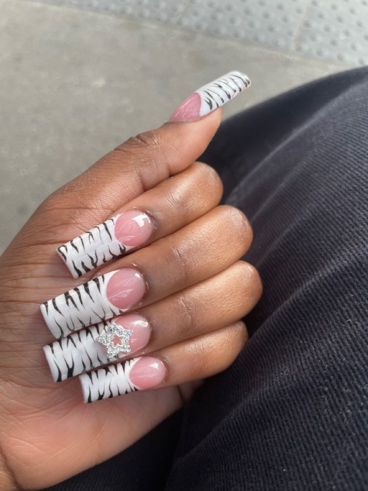 Bold Zebra-Striped Nail Design with Soft Pink Base and Glamorous Accents.