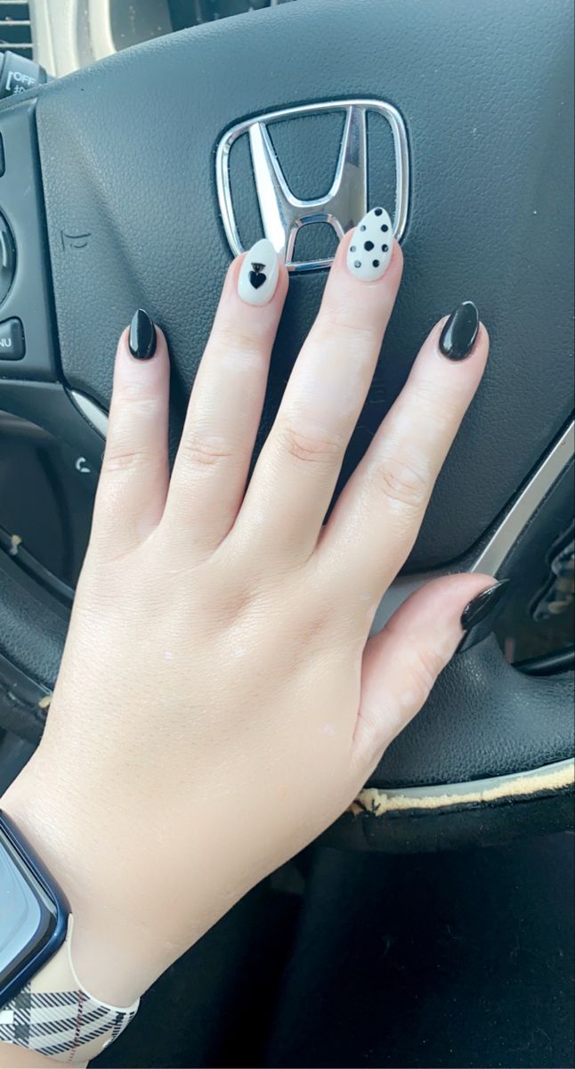 Chic Black and White Nail Design with Playful Patterns and Glossy Accents