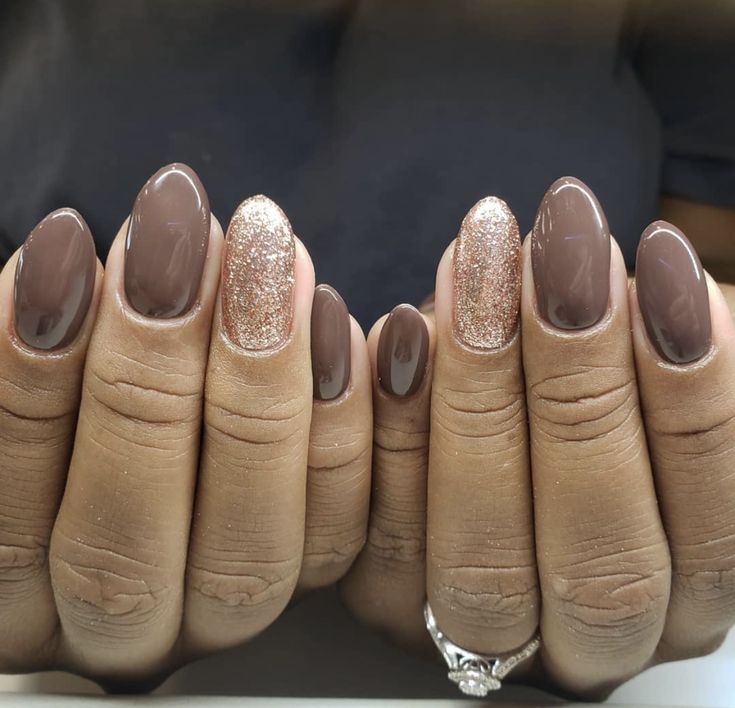 Chic Almond-Shaped Nails: Muted Brown Base with Shimmering Gold Accents.