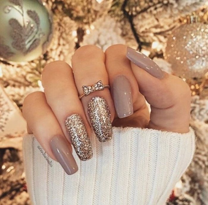 Sophisticated Holiday Nail Design: Taupe Base with Glitter Accents and Bow Detail.