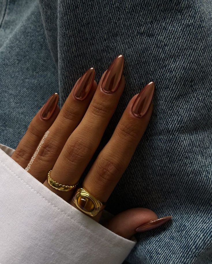 Elegant Almond-Shaped Brown Nails Enhanced by Glossy Finish and Chic Gold Rings.