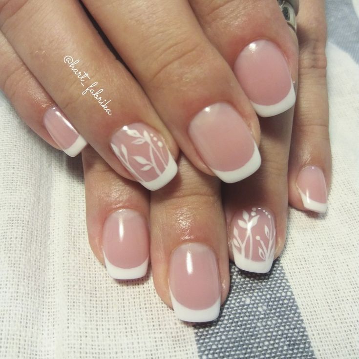 Chic French Manicure with Floral Accents for a Whimsical Touch.