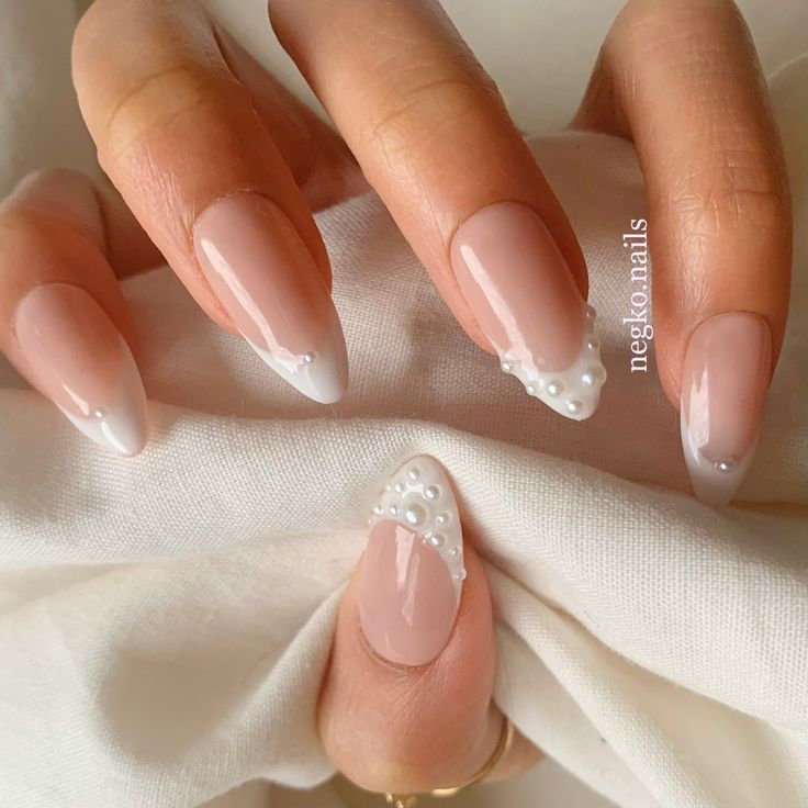 Chic Almond-Shaped Nail Art with Nude Base, White Tips, and Elegant Pearl Accents.