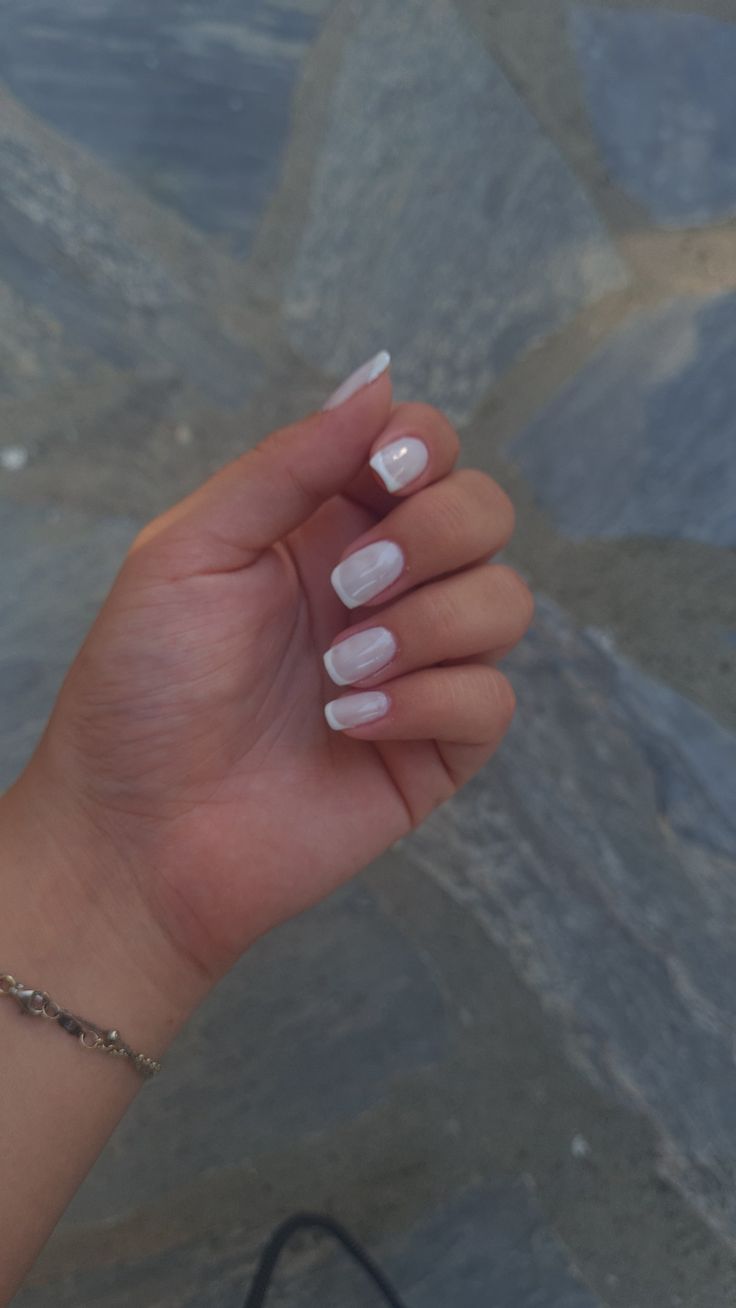 Sophisticated Minimalist Nail Design: Soft White Base and Delicate Tips.