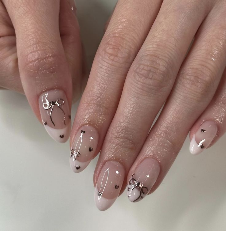 Chic Nail Design: Soft Nude Base with Elegant White Tips and Delicate Heart Accents.