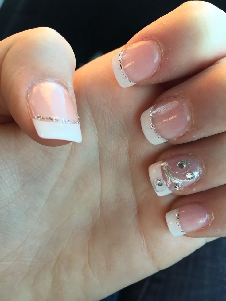 Chic French Tip Nail Design with Glamorous Silver Accents and Sparkly Embellishments.