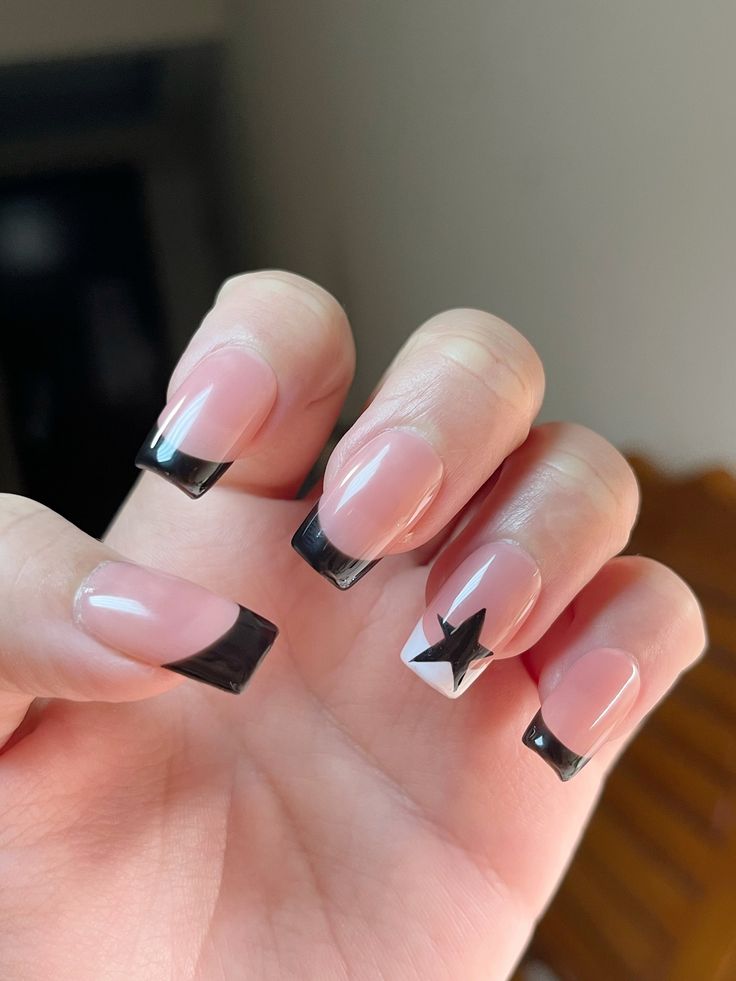 Sophisticated Nude and Black Nail Design with Geometric Star Accents