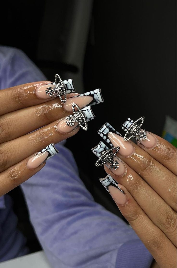 Chic Elongated Tip Nail Design with Bold Patterns and Sparkling Accents.