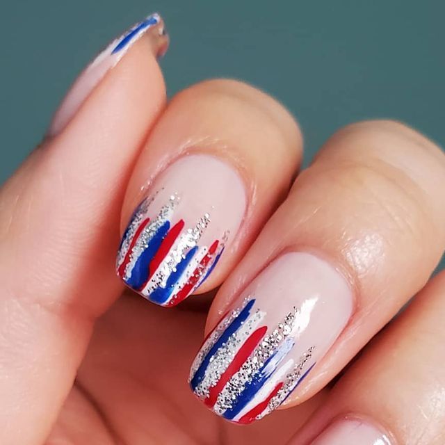 Vibrant Red and Blue Striped Nail Design with Shimmering Silver Accents for a Chic Look.