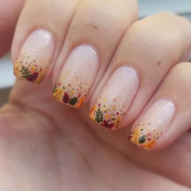 Warm Autumn-Inspired Nail Design with Floral Patterns and Gold Accents.