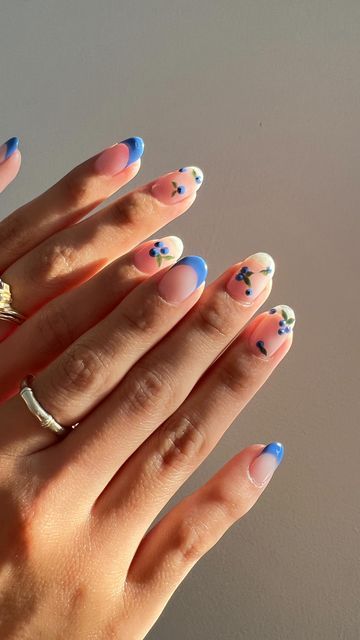 Delicate Pastel Floral Nail Art with Pink Base and Blue French Tips.