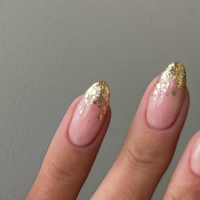 Charming Gradient Nude Nails with Shimmering Gold Glitter for Elegant Glamour.