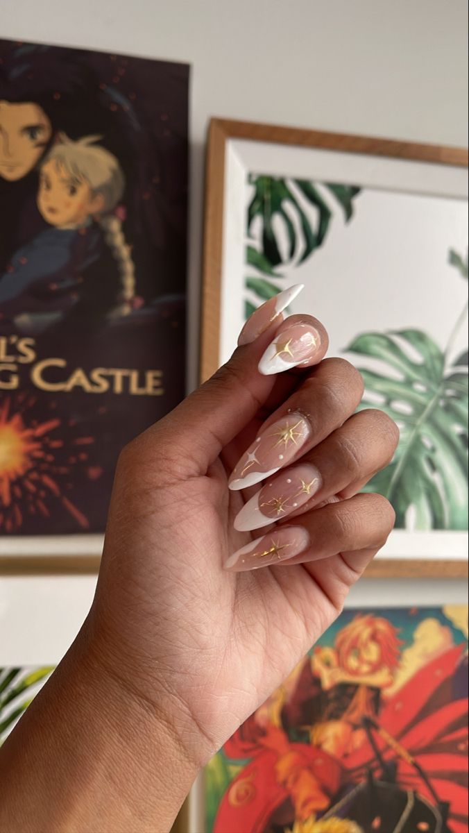 Elegant Almond-Shaped Nude Nails with White Tips and Artistic Gold Star Designs