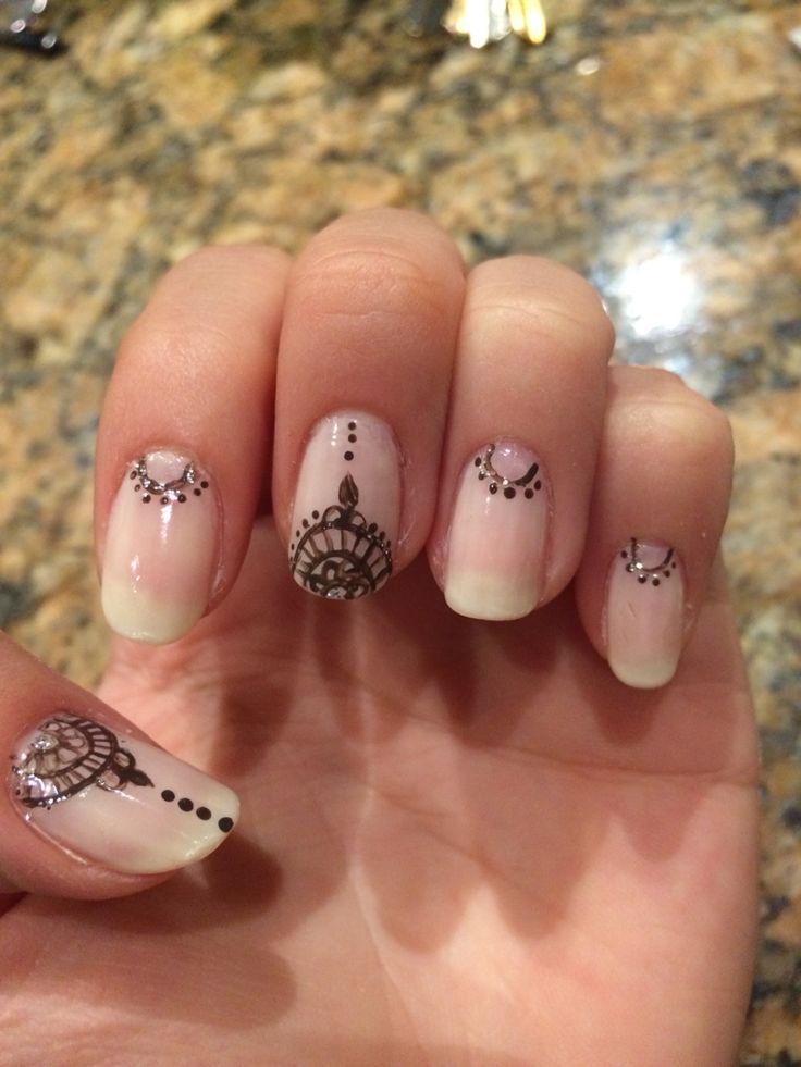 Sophisticated Sheer Pink Nail Design with Intricate Black Patterns and Decorative Gems.