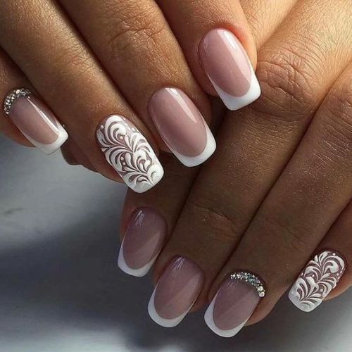 Sophisticated French Manicure with Intricate Swirls and Sparkling Embellishments.