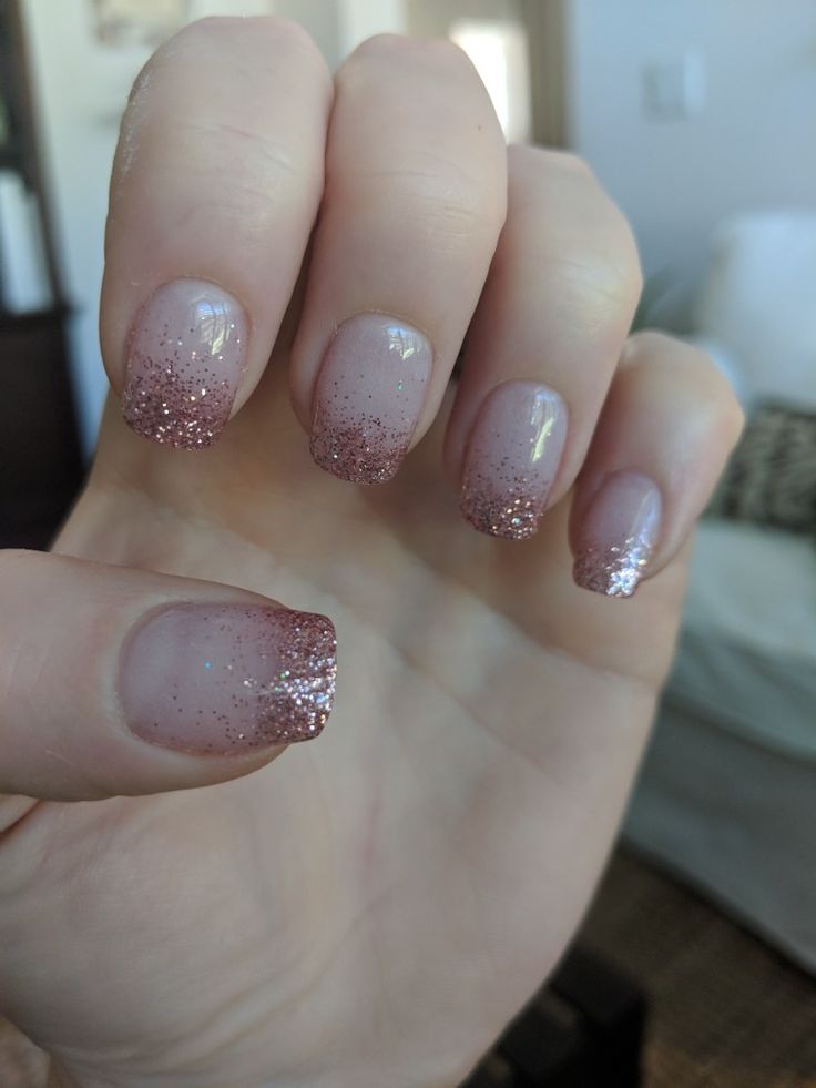 Elegant Ombre Nail Design: Soft Nude Base with Sparkling Rose Gold Tips and Fine Glitter Accent.