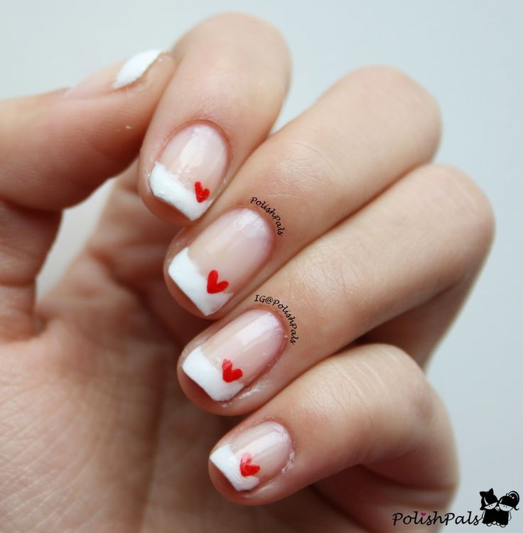 Whimsical French Manicure with Charming Red Heart Accents for a Cheerful Look.