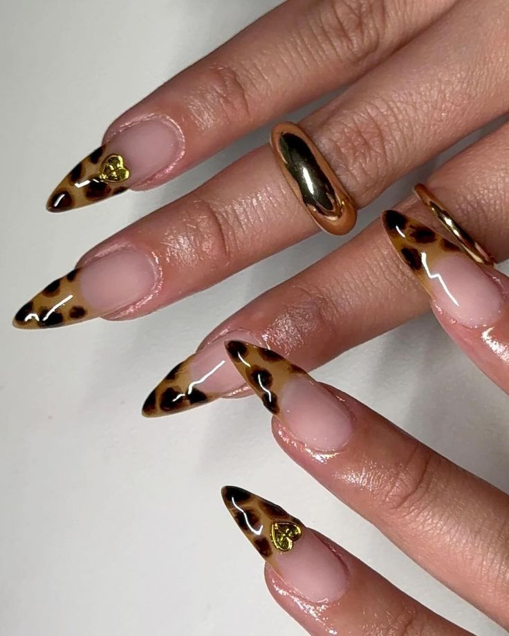 Chic Leopard Print Nails with Elegant Nude and Black Tips, Gold Accents, and Matching Rings.