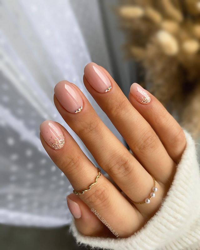 Sophisticated Elegance: Nude Nails with Subtle Sparkling Accents and Chic Rings.