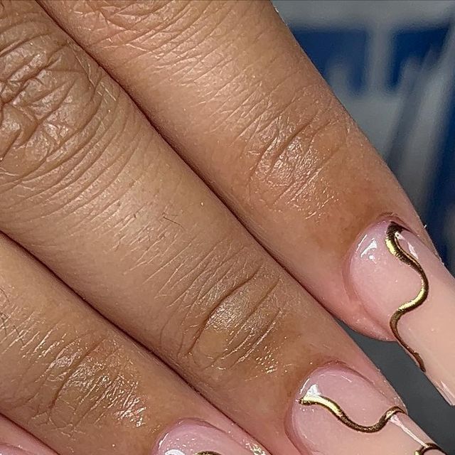 Sophisticated Nude Nail Design with Delicate Gold Wave Accents