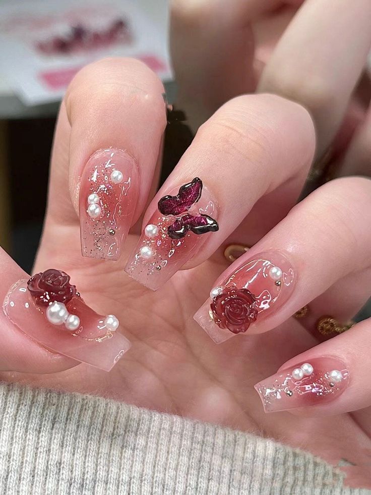 Elegant Extended Nail Design with Rose Embellishments and Butterfly Accent.