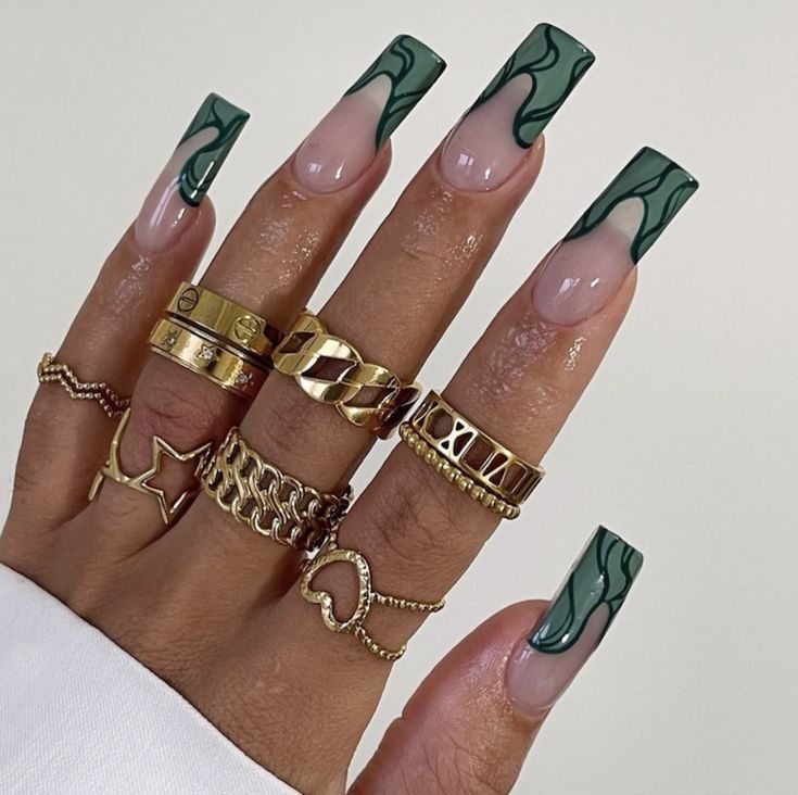 Sophisticated Marbled Green and Nude Nail Design with Bold Accents and Gold Accessories.