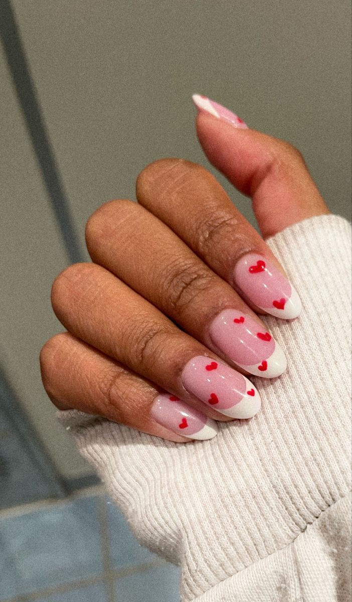 Charming Soft Pink Nail Design with Red Hearts and Elegant White Tips.