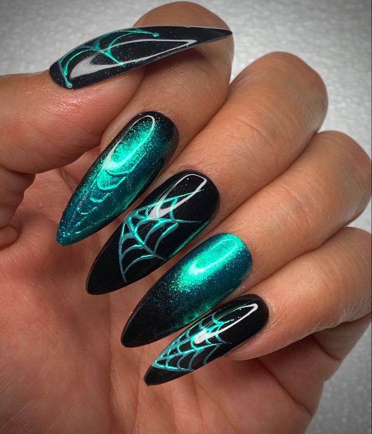 Bold Halloween Nail Design: Shimmering Teal and Deep Black with Whimsical Spiderweb Patterns.