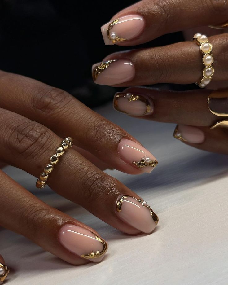 Sophisticated Nude Nail Design with Glossy Gold Accents and Pearl-Embellished Rings.