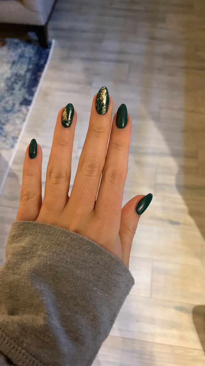 Sophisticated Nail Design: Deep Green Polish with Sparkling Gold Accent for a Trendy Twist.