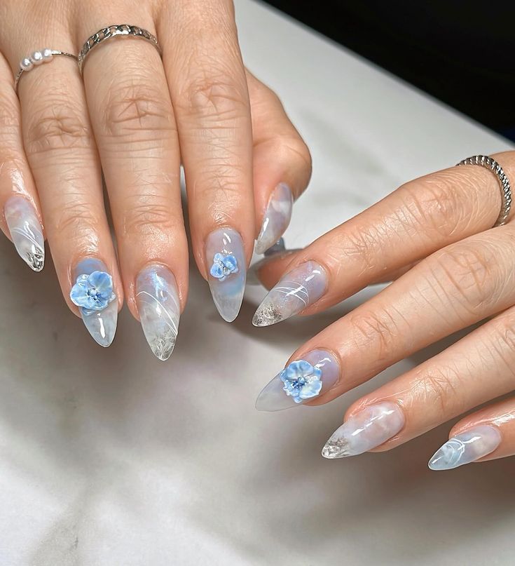 Whimsical Sophistication: Elegant Pointed Tip Nail Design with Translucent Finish and Floral Accents.