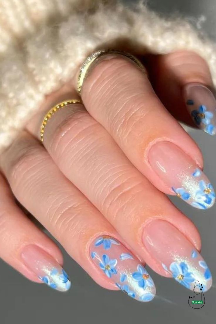 Elegant Floral Nail Art: Delicate Blue Flowers and Gold Accents on Soft Nude Background