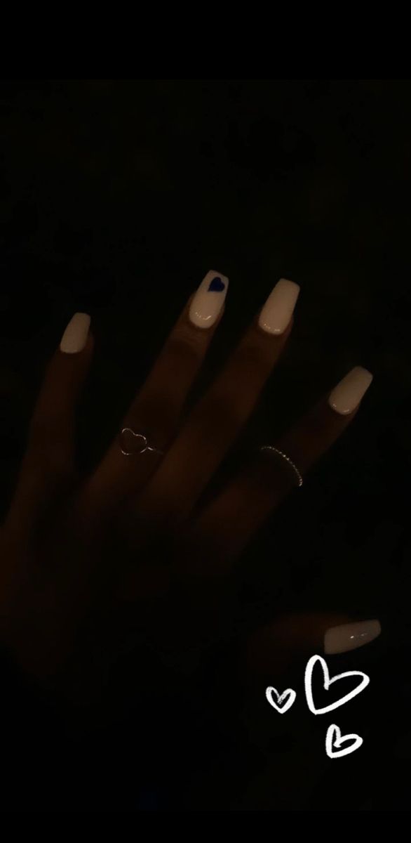 Chic White Manicure with Blue Heart Accent and Delicate Rings.