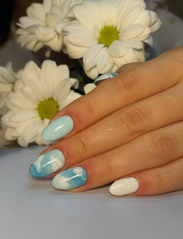 Chic Blue and White Nail Art with Marble Effect and Floral Background.