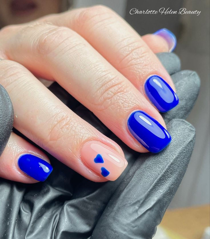 Charming Glossy Nail Design: Vibrant Blue and Soft Pink with Whimsical Heart Accents.