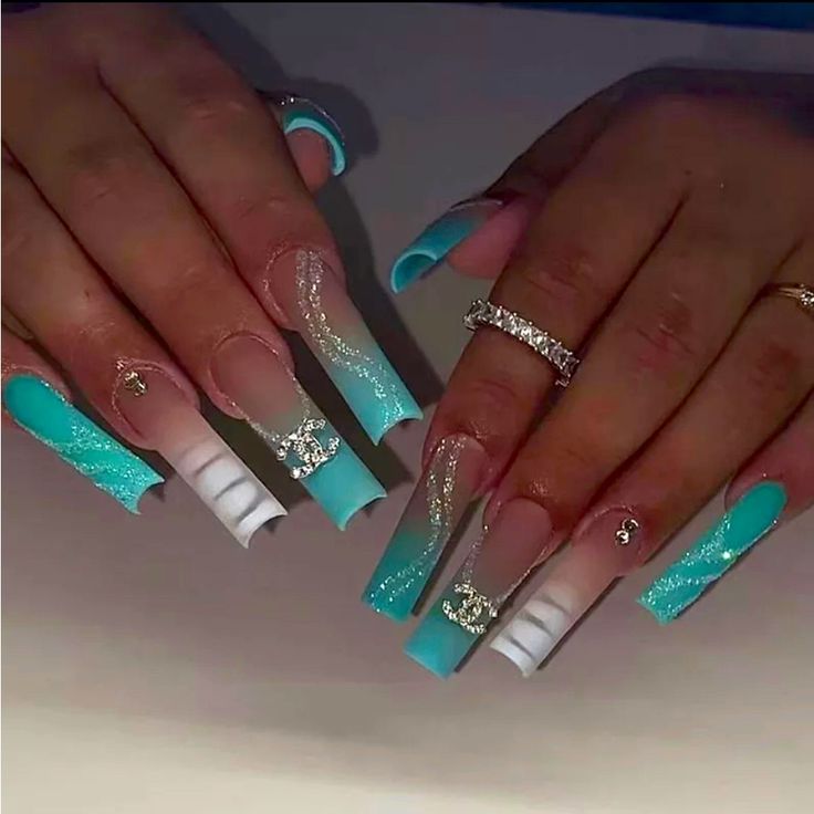 Chic Turquoise and White Acrylic Nail Design with Shimmering Accents and Elegant Finishes.