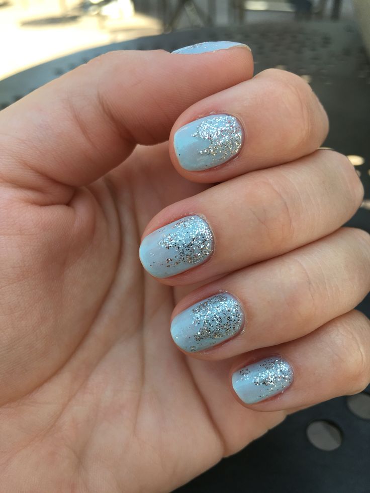 Elegant Soft Blue and Shimmering Silver Glitter Nail Art for Festive Occasions.