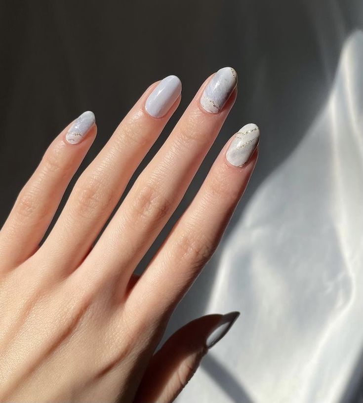 Refined Pastel Blue Nail Design with Marbled Accents and Elegant Finish