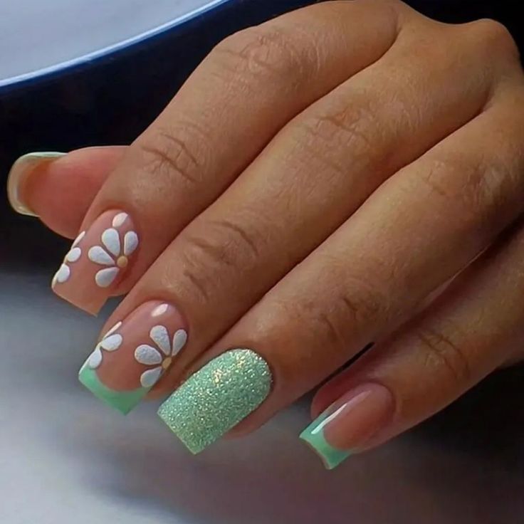 Elegant Floral Nail Design with White Daisies, Glitter Accent, and Mint Green Tips.