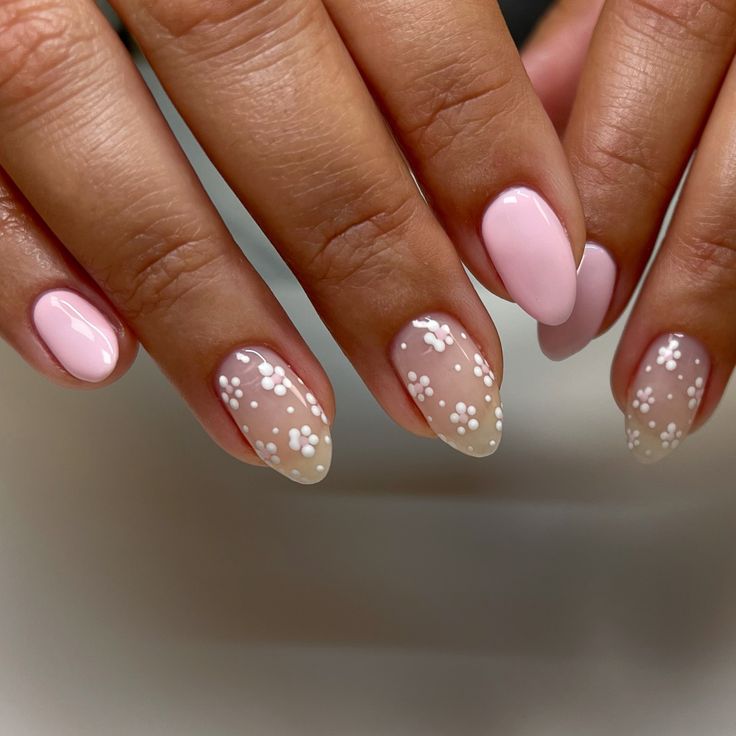 Charming Floral Nail Design: Soft Pink Base with Transparent Tips and Tiny White Flowers.