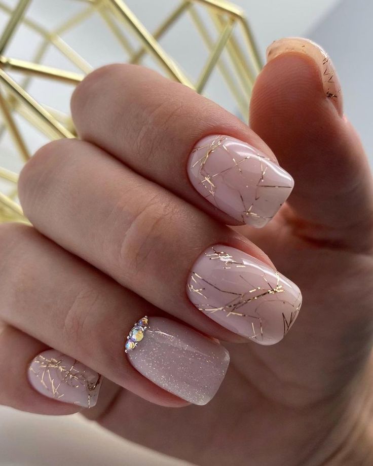 Sophisticated Soft Pink Nail Design with Delicate Gold Accents and Sparkling Gem Detail