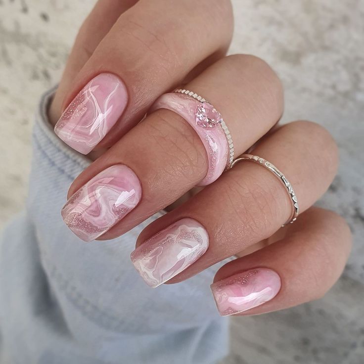 Chic Pink Marble Gradient Nail Design with Shiny Finish and Delicate Silver Accents.