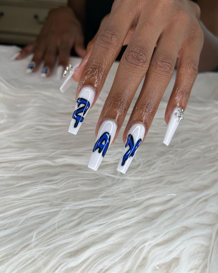 Elegant Acrylic Nails: Bold White Base with Striking Blue Designs and Intricate Patterns