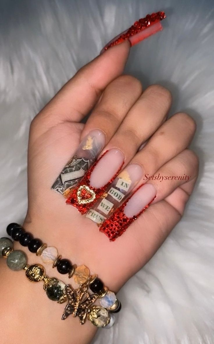 Bold Nail Design: Striking Red Accents with Intricate Money-Themed Art and Sparkling Textures.