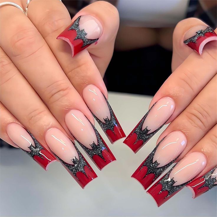 Bold Red and Black Nail Design with Bat Wing Details for Dramatic Flair.