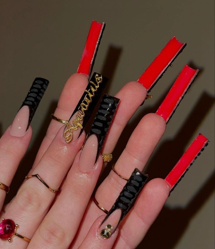 Striking Red and Black Bold Nail Design with Intricate Metallic Accents.