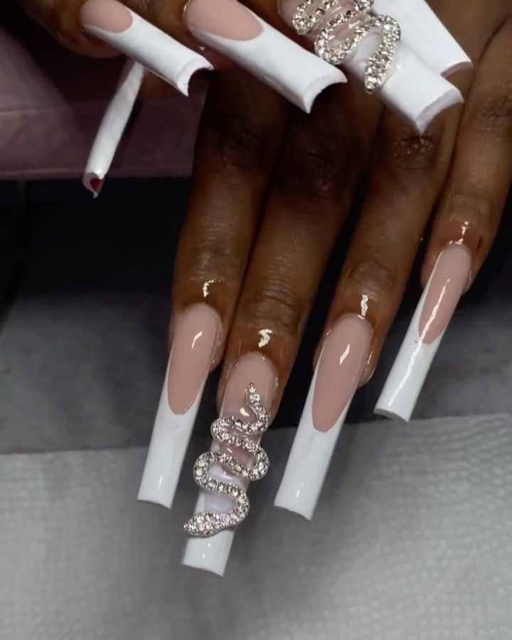 Chic Nude and White Nail Design with Striking Jeweled Snake Motif.