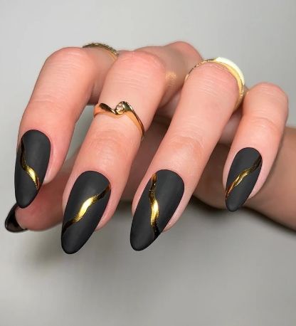 Elegant Matte Black Nail Design with Glamorous Gold Accents.