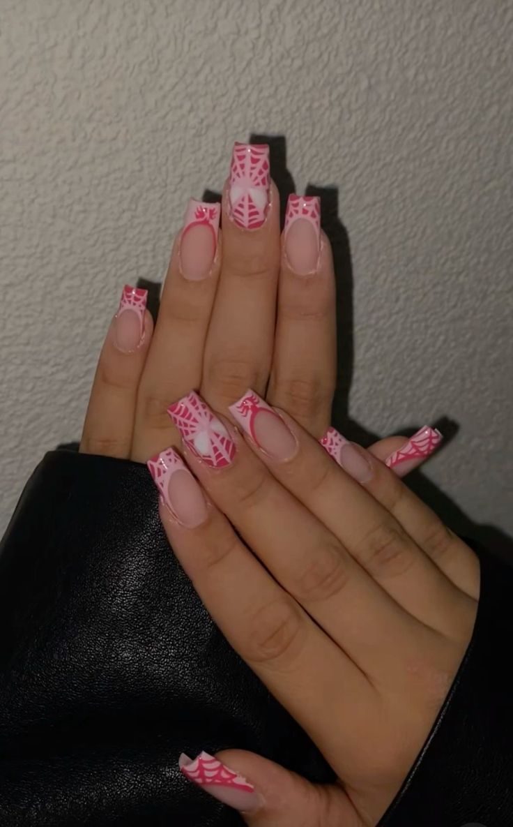 Playful Pink and White Nail Design with Intricate Spider Web Patterns.